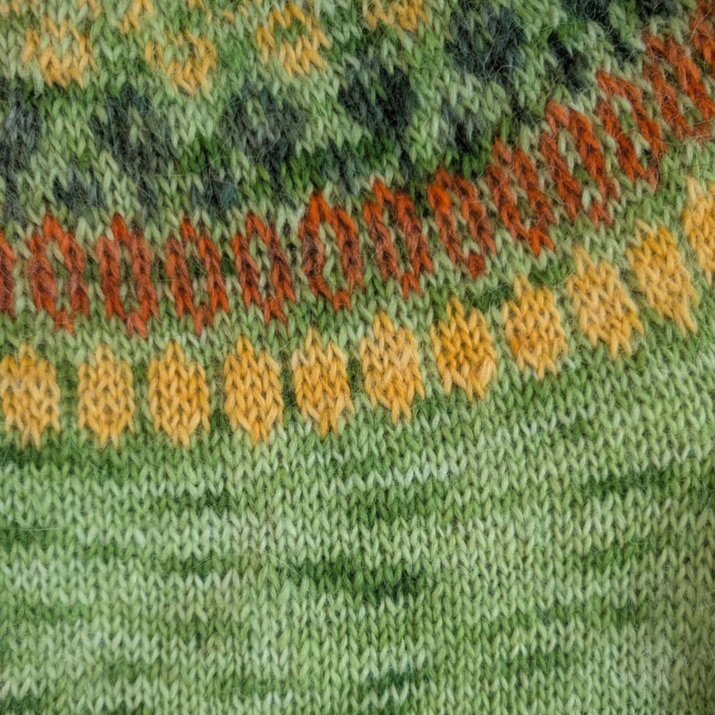 Knitted Icelandic sweater pattern in green tones using hand-dyed lopi yarn