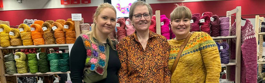 Hörpugull team at a knitting festival booth surrounded by colourful hand-dyed Icelandic wool.