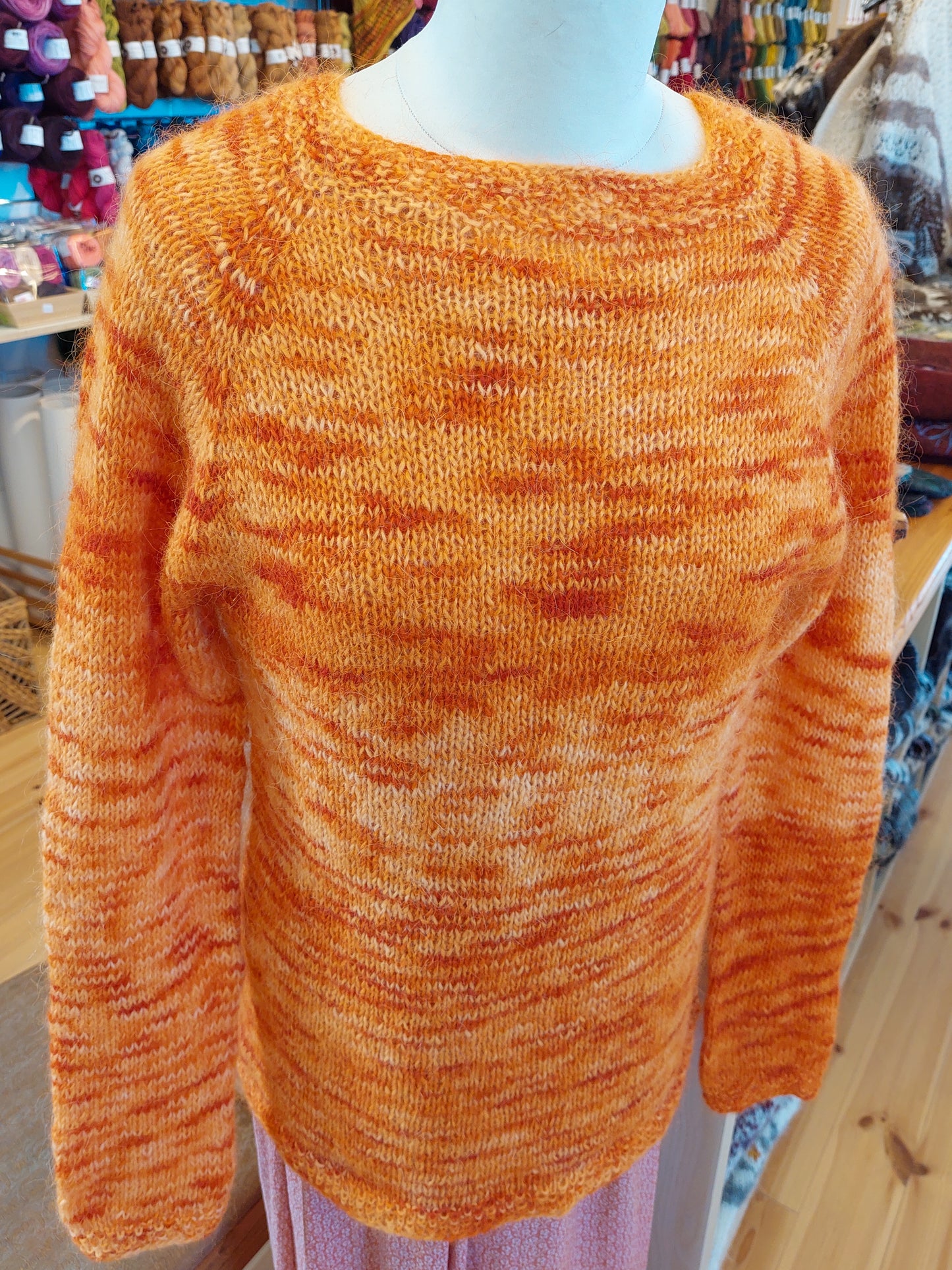 Bergur hiking sweater front view knitted with Icelandic lopi yarn in warm orange tones displayed indoors