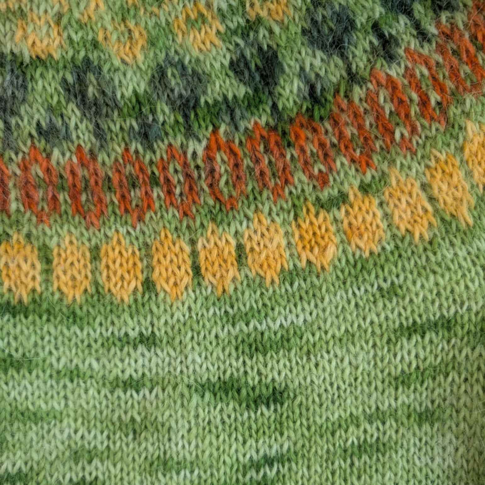 Knitted Icelandic sweater pattern in green tones using hand-dyed lopi yarn