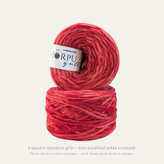 Hand-dyed Icelandic lopi yarn in warm pink-red tones inspired by moss campion flowers