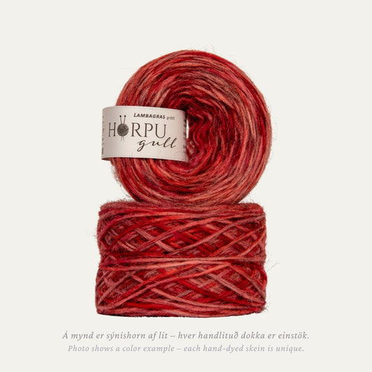 Hand-dyed Icelandic lopi yarn inspired by moss campion in warm red and pink tones with a natural grey base